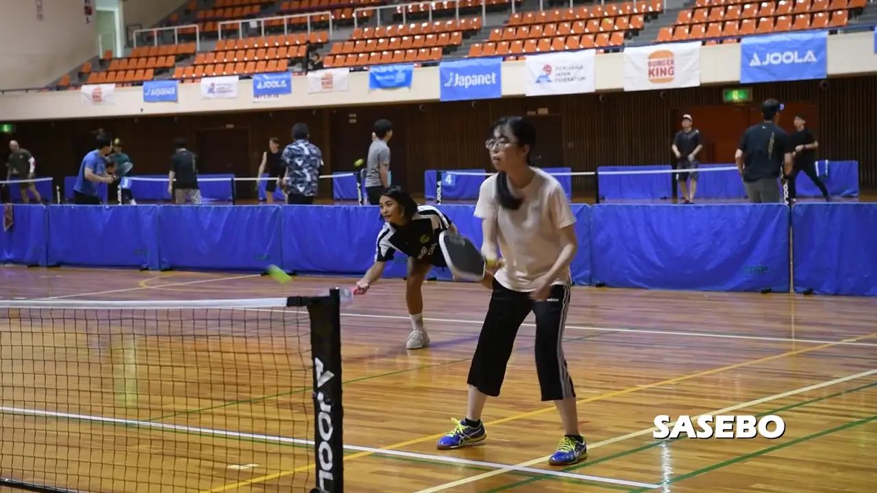 Players sharing an indoor pickleball court
